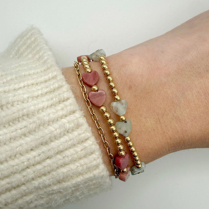 Bracelet with heart-shaped beads on a wrist against a white background