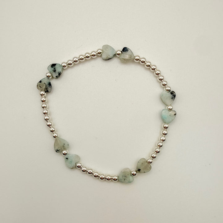 Bracelet with heart-shaped green stones on a white background