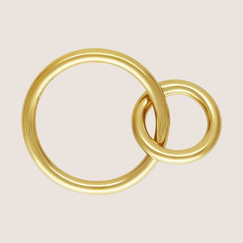 Two interlocking gold rings on a beige background