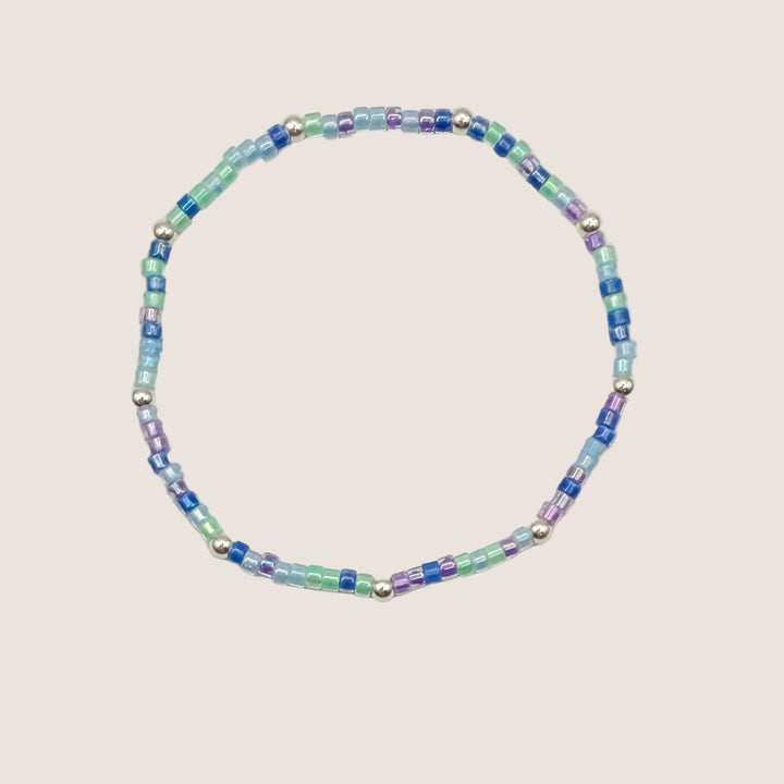 Multicolored beaded bracelet on a light gray background