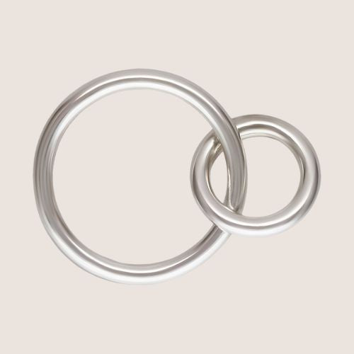 Two interlocking silver rings on a beige background